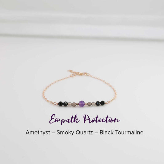 Dainty Empath Protection Bracelet with a 4 mm Amethyst stone in the middle, 2 mm  gold accent balls, smoky quarts, and black tourmaline healing crystals. The combination of these crystals makes a perfect protection for all empaths.