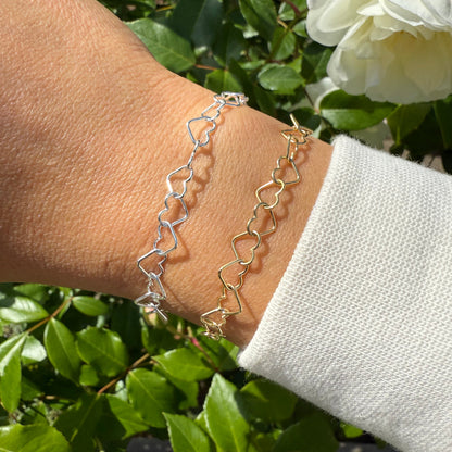 Adjustable heart bracelet in both silver and gold. Shown on an arm wearing