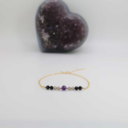 The Empath Protection Bracelet is designed to block negative energy and provide healing benefits. This healing crystal bracelet features a selection of powerful stones, including amethyst, smoky quartz, and black tourmaline, known for their protective and deflective properties against bad energy. 

Available in rose gold-filled, yellow gold-filled, or sterling silver options, this dainty bracelet is handcrafted and infused with the energy of healing crystals.