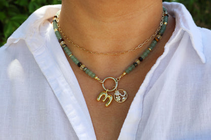 Prosperity Necklace with green aventurine crystals and gold charm on a white shirts