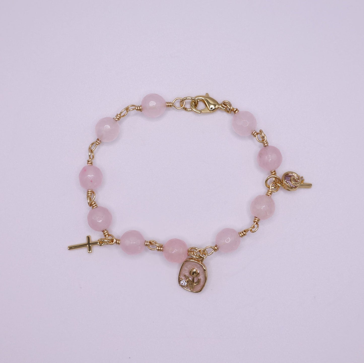 Rose quartz  rosary beaded bracelet with gold religious charms. 
