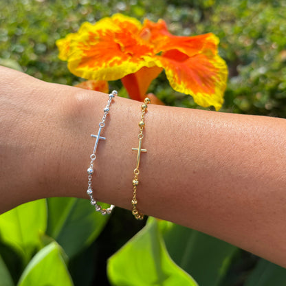 Bracelets on a wrist with a blurred background of flowers and greenery