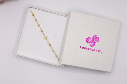 Gold cross bracelet in a gift box with 3 Rosebuds Co. logo – elegant religious gift for women, minimalist faith bracelet for special occasions.