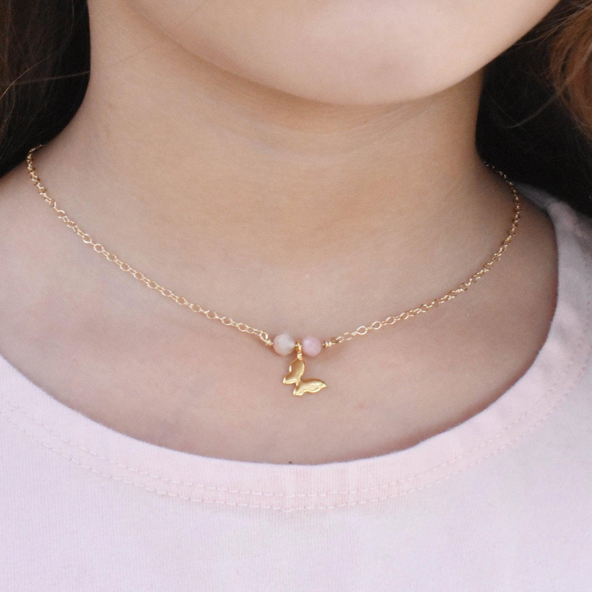 Dainty children's butterfly necklace with choice of pink opals or amethyst gemstones. This necklace is part of the children's collection. It features a gold-filled chain and your selection of semi precious healing gemstone crystals that are ideal for children for their soothing energy.