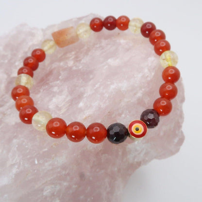 Phoenix Rising offers protection against the evil eye and promotes healing for the Solar, Sacral, and Root Chakras. It includes Carnelian, Citrine, Sunstone, and Garnet in its composition.. Infused with Reiki Healing - 3Rosebudsco.com- 3Rosebudsco.com