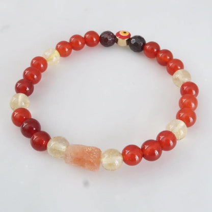 Phoenix Rising crystal bracelet for Solar, Sacral, and Root Chakra healing, featuring Carnelian, Citrine, Sunstone, and Garnet with evil eye protection. 3rosebudsco.com